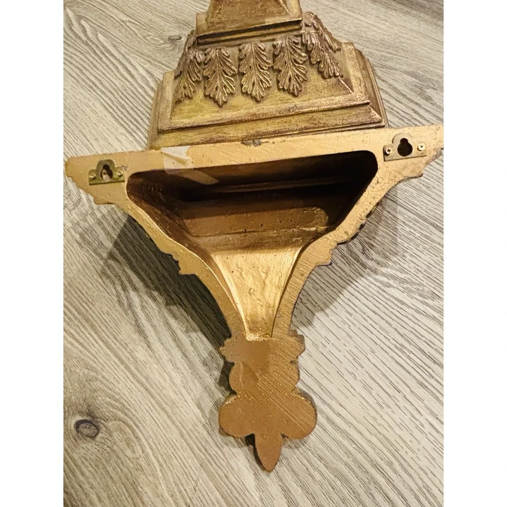 Vintage gold-toned decorative wall shelves with floral motifs.